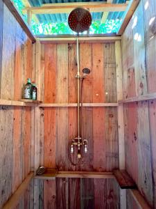 a shower in a room with wooden walls at Glamping Luz Olive in Combret