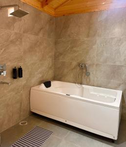 a white bath tub in a bathroom at The Walnut Homes- Luxury Pine Cottages in Bhīm Tāl