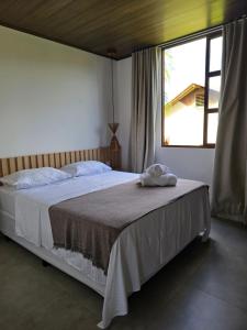 a bedroom with a large bed with a window at Portal do Kite in Barra Grande