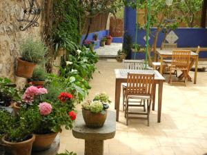 eine Terrasse mit Tischen, Stühlen und Topfpflanzen in der Unterkunft Casa Bougainvillea in Sóller