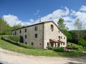 a large stone building on a grassy hill at Tenuta Valdea in Firenzuola