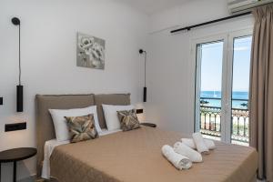 a bedroom with a bed with a view of the ocean at Bratis Apartments in Keri