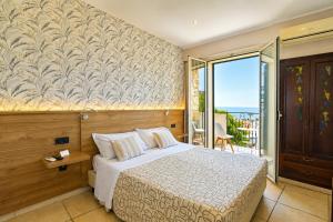 Hotel & Apartments Villa Linda في جيارديني ناكسوس: غرفة فندق بها سرير وشرفة