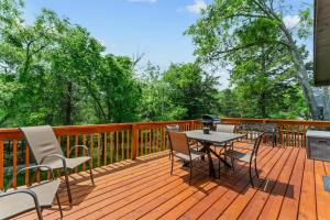 a wooden deck with a table and chairs on it at Whispering Bass Lodge 3BDR in Kimberling City