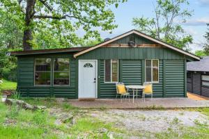 a green shed with a table and two chairs at Whispering Bass Lodge 3BDR in Kimberling City