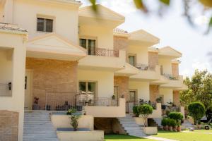 a building with stairs and plants in front of it at Ithaki Apartments in Paramythia