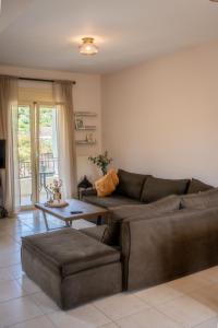 a living room with a brown couch and a table at Ithaki Apartments in Paramythia +22 photos