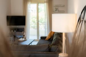 a living room with a couch and a lamp at Ithaki Apartments in Paramythia