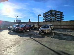 a group of cars parked in a parking lot at Departamento Edificio Centro Osorno in Osorno +9 photos