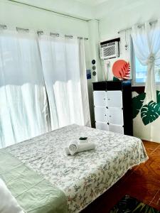 a bedroom with a bed with a white bedspread at Bulan Guesthouse in San Isidro