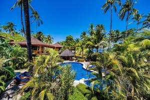 an aerial view of a resort with a pool and palm trees at Tambor Tropical Beach Resort- Adults Only in Tambor