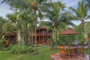a house with a table and chairs and palm trees at Tambor Tropical Beach Resort- Adults Only in Tambor +34 photos