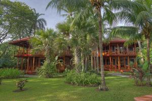 a building with palm trees in front of it at Tambor Tropical Beach Resort- Adults Only in Tambor