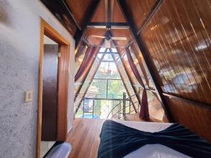 a room with a bed and a large window at Chalé da lagoa in Lagoa Santa