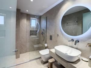 a bathroom with a sink and a toilet and a mirror at Bratis Apartments in Keri +105 photos
