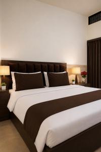 a large bed in a bedroom with two lamps at Hotel HP Palace in Gorakhpur