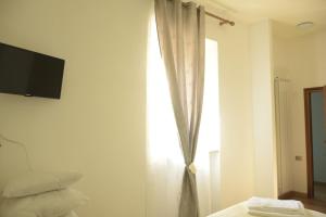 a bedroom with a window with a television on the wall at La Tana Del Cinghiale in Tirli
