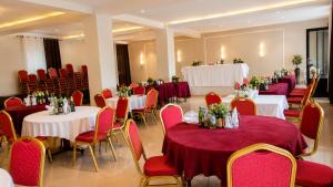 a banquet hall with white tables and red chairs at La Planete Hotel in Rubavu +66 photos