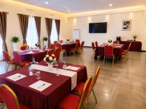 a conference room with tables and chairs and a flat screen tv at La Planete Hotel in Rubavu