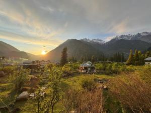 a sunset over a village with mountains in the background at Enter The Wild in Kalgha