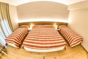 A bed or beds in a room at Grand Hotel Europa Rivisondoli Centro