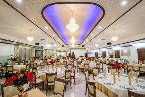 a banquet hall with tables and chairs and a large ceiling at Hotel Forum in Pazardzhik