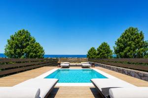 a swimming pool with chaise lounges on a deck at Villa Liana in Petalidi