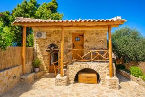a stone fireplace in front of a building with a roof at Villa Liana in Petalidi
