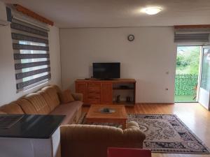 a living room with a couch and a tv at Apartment Boka in SJJ