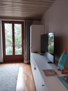 a kitchen with a refrigerator and a tv on a counter at Chez Pascale & Pierre in Kogenheim +3 photos