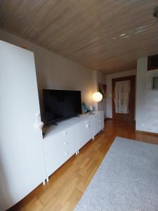 a living room with a flat screen tv on a white cabinet at Chez Pascale & Pierre in Kogenheim