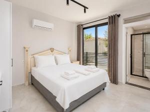 a white bedroom with a bed and a window at Villa Exclusive Paradise 2 in Dalyan
