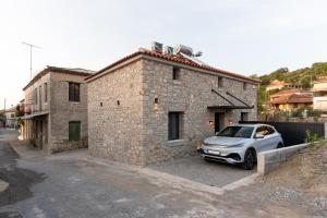 a car parked in front of a stone building at Olea Stone Villa in Pylos