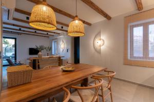 a dining room with a wooden table and chairs at Olea Stone Villa in Pylos