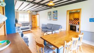 a living room with a table and a couch at Perewinkle Cottage - Portmagee in Lateeve