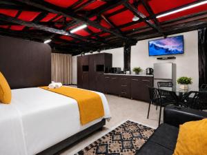a bedroom with a large bed and a kitchen at Royal Palms Guest House in Port Elizabeth