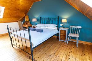 a bedroom with a bed and a chair in a room at Perewinkle Cottage - Portmagee in Lateeve