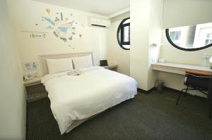 a bedroom with a white bed and a window at Century Hotel in Kaohsiung