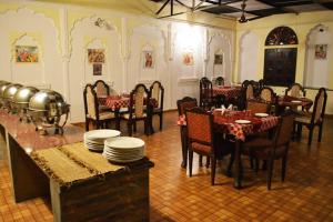 a dining room with tables and chairs and plates on tables at Sajjan Bagh A-Heritage Resort in Pushkar