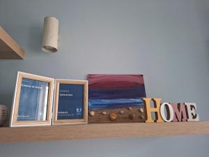 a shelf with three books on a wall at Casina al mare in Cecina