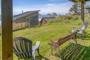 two chairs and a bench in a yard with the ocean at Serendipity -A Happy Surprise Unit B in Oceanside