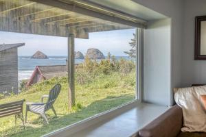 a living room with a large window looking out at the ocean at Serendipity -A Happy Surprise Unit B in Oceanside