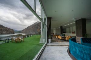 a room with a balcony with a view of the water at Pearl Continental Attabad Lake, Hunza in Hunza Valley