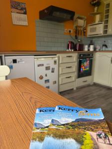a kitchen with a table with two magazines on it at Hannah's Cottage in Farranfore