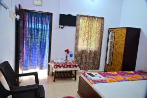 a bedroom with a bed and a chair and a table at SUN SHINE RESORT in Neil Island