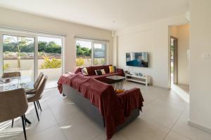 a living room with a couch and a tv at The Icon 001 - Superior 2BR Apartment with Pool & Gym, Mythical Seas - Protaras in Paralimni
