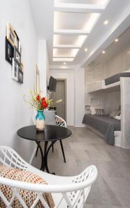 a living room with a table and chairs and a bedroom at Ione Inn in Naxos Chora