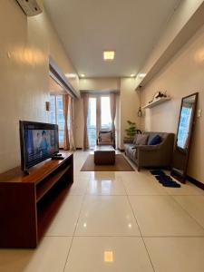 a living room with a television and a couch at Luxe Gold Mactan in Mactan