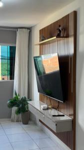 a living room with a tv on a wall at 1- Apartamento aconchegante 1200m do Centro in Serra Talhada