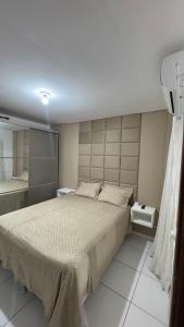 a bedroom with a large bed and a mirror at 1- Apartamento aconchegante 1200m do Centro in Serra Talhada